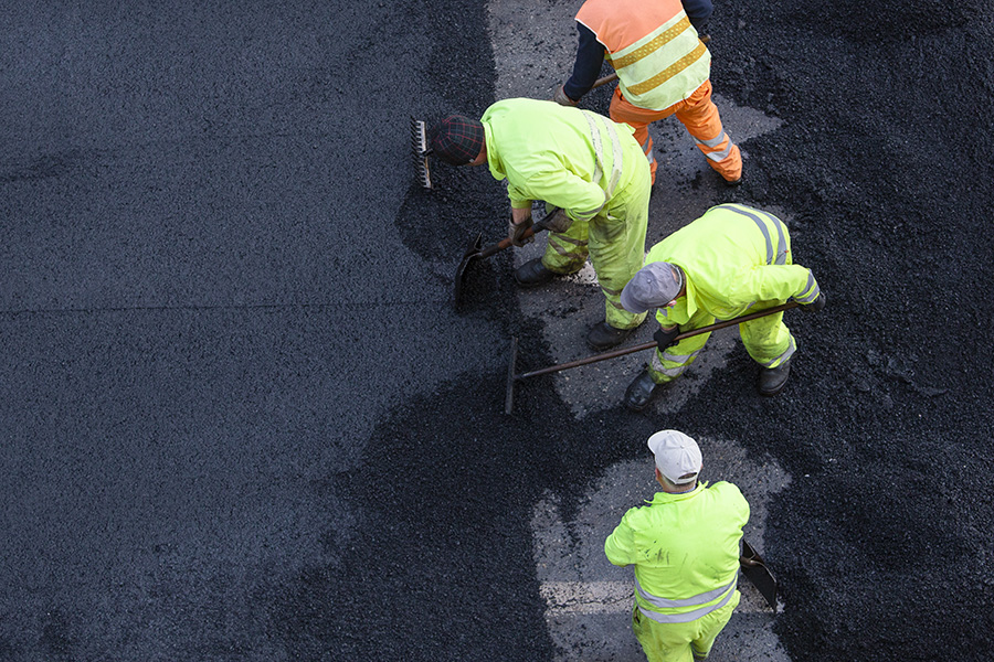 asphalt workers maintaining a parking lot